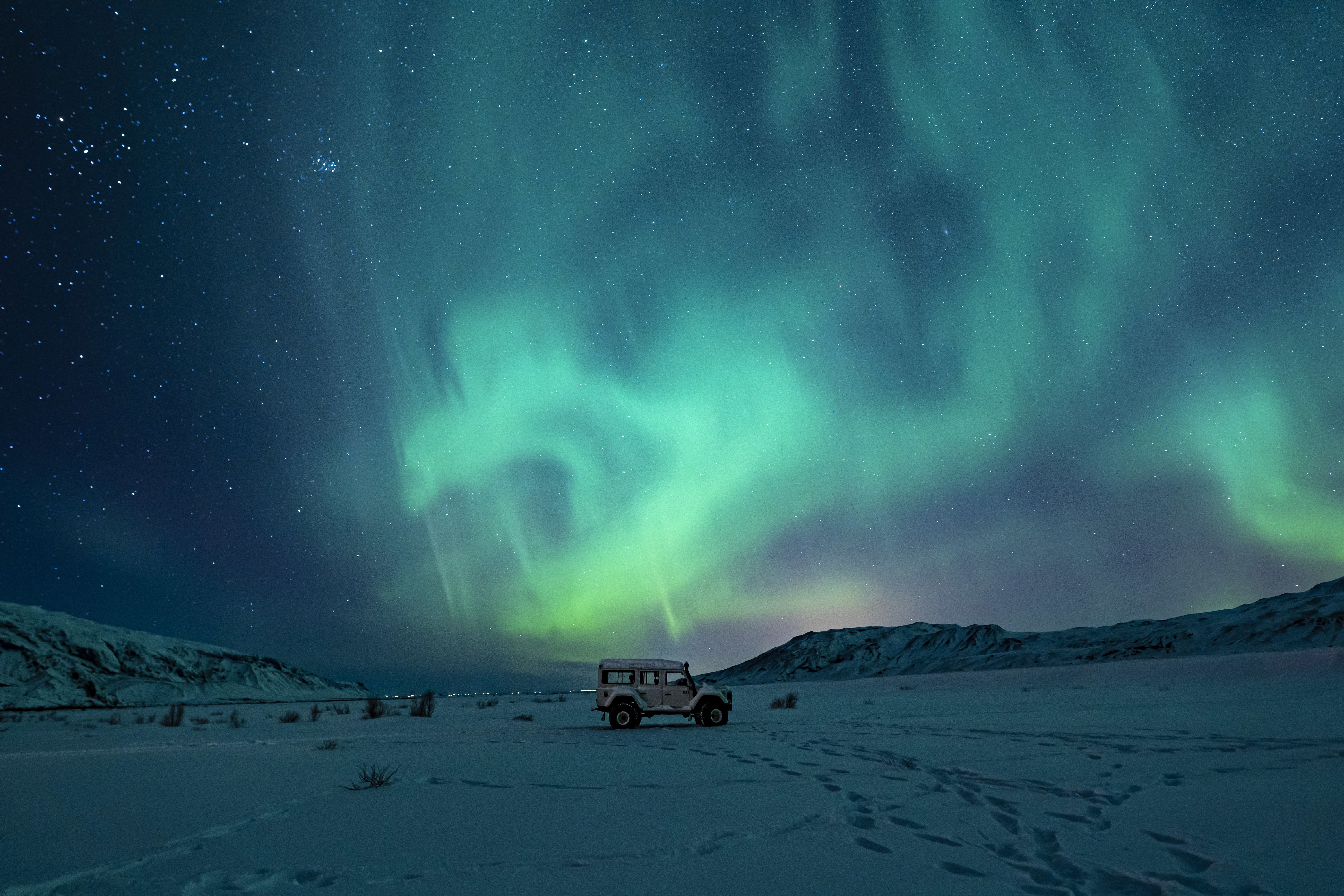 black-suv-snow-covered-field-green-aurora-lights.jpg