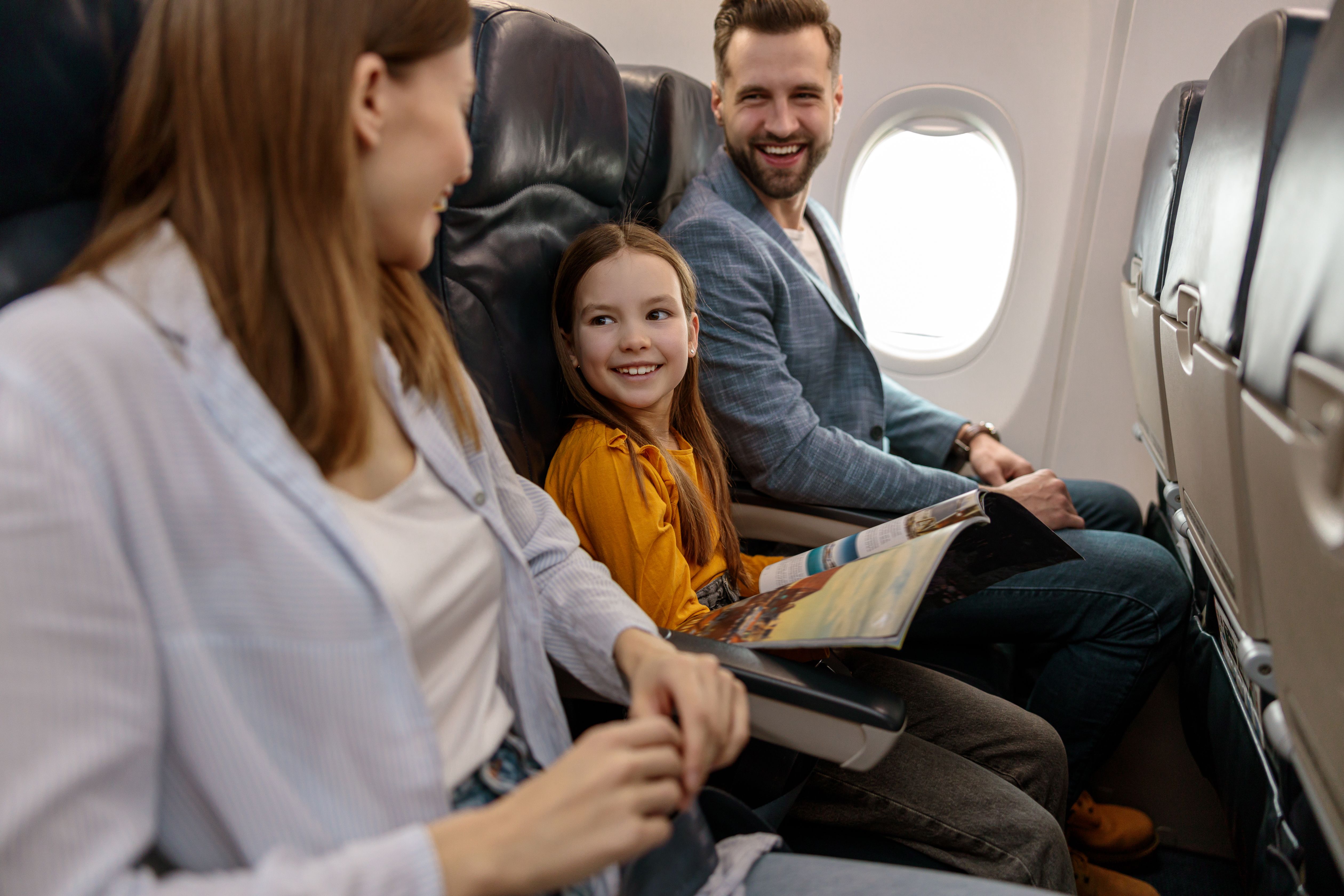 cheerful-little-girl-traveling-with-parents-airplane.jpg