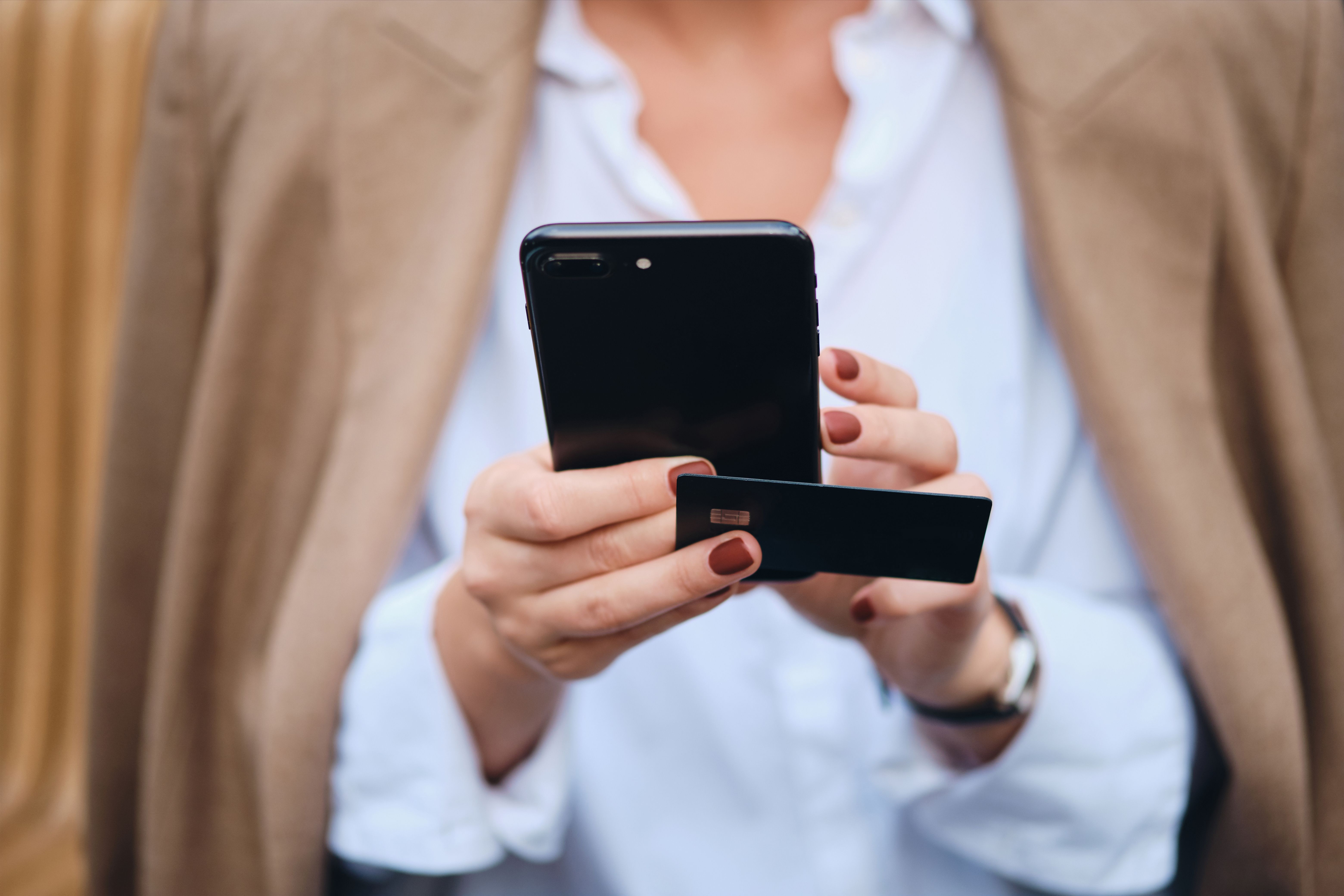 close-up-stylish-businesswoman-with-credit-card-using-cellphone-outdoor.jpg