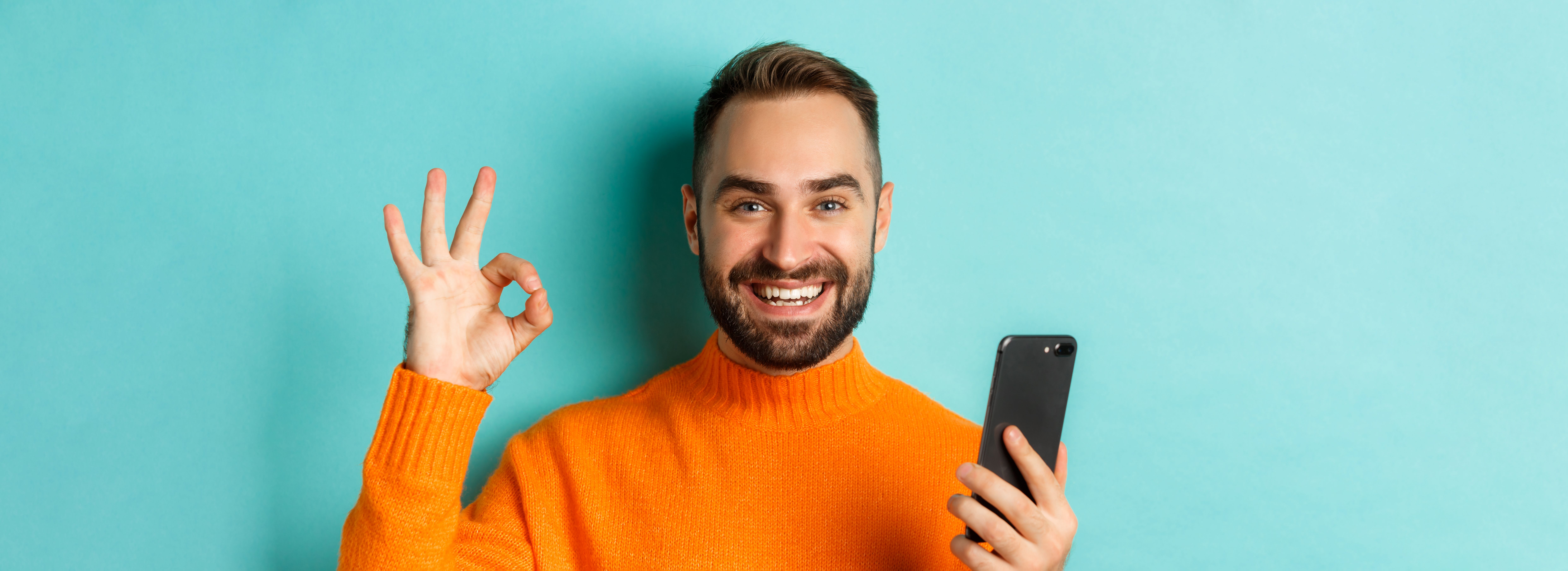 closeup-bearded-man-holding-smartphone-showing-okay-sign-recommending-mobile-app-standing-sat.jpg
