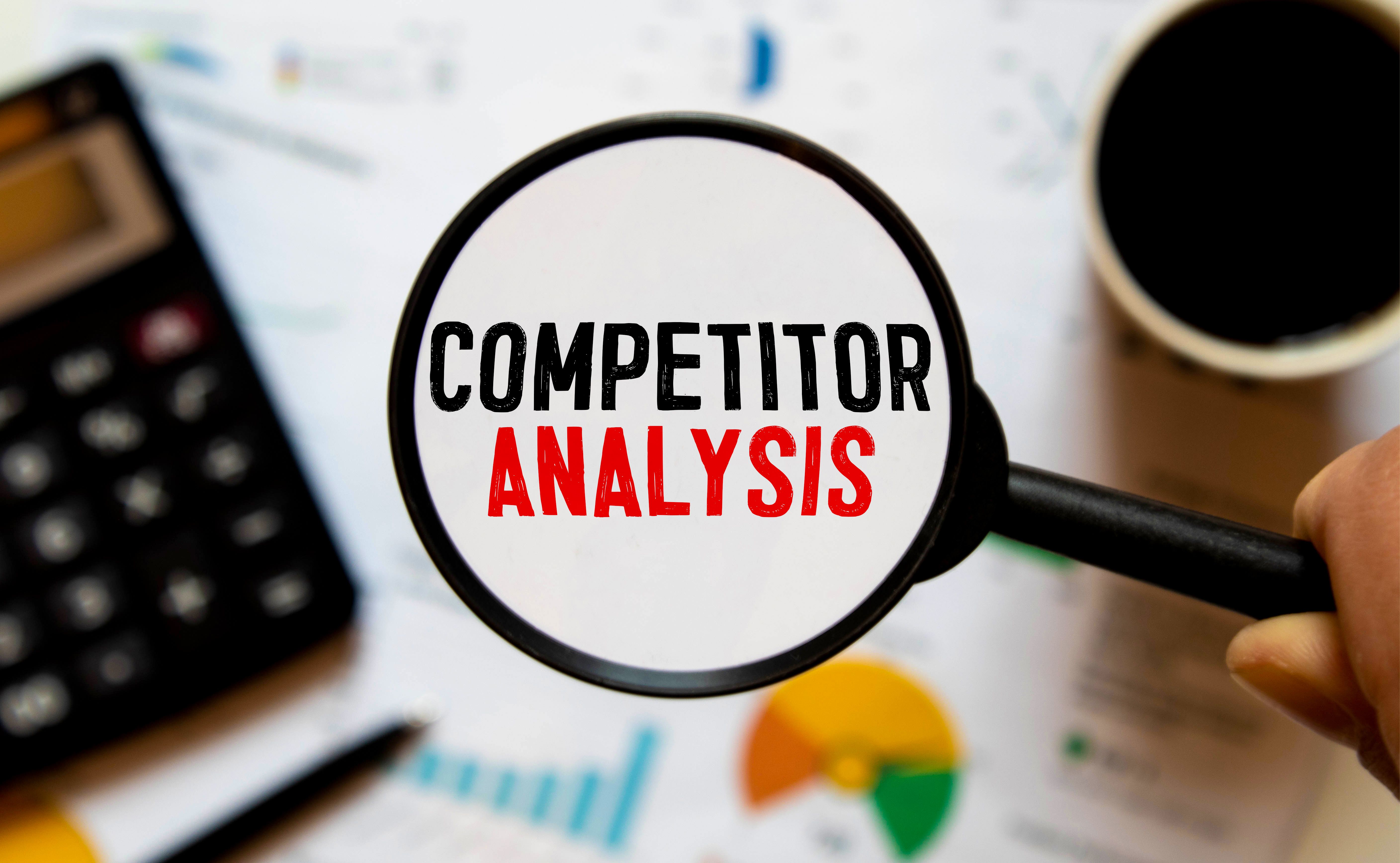 competitor-analysis-word-with-hand-holding-magnifying-glass-jigsaw-puzzle-selective-focus.jpg