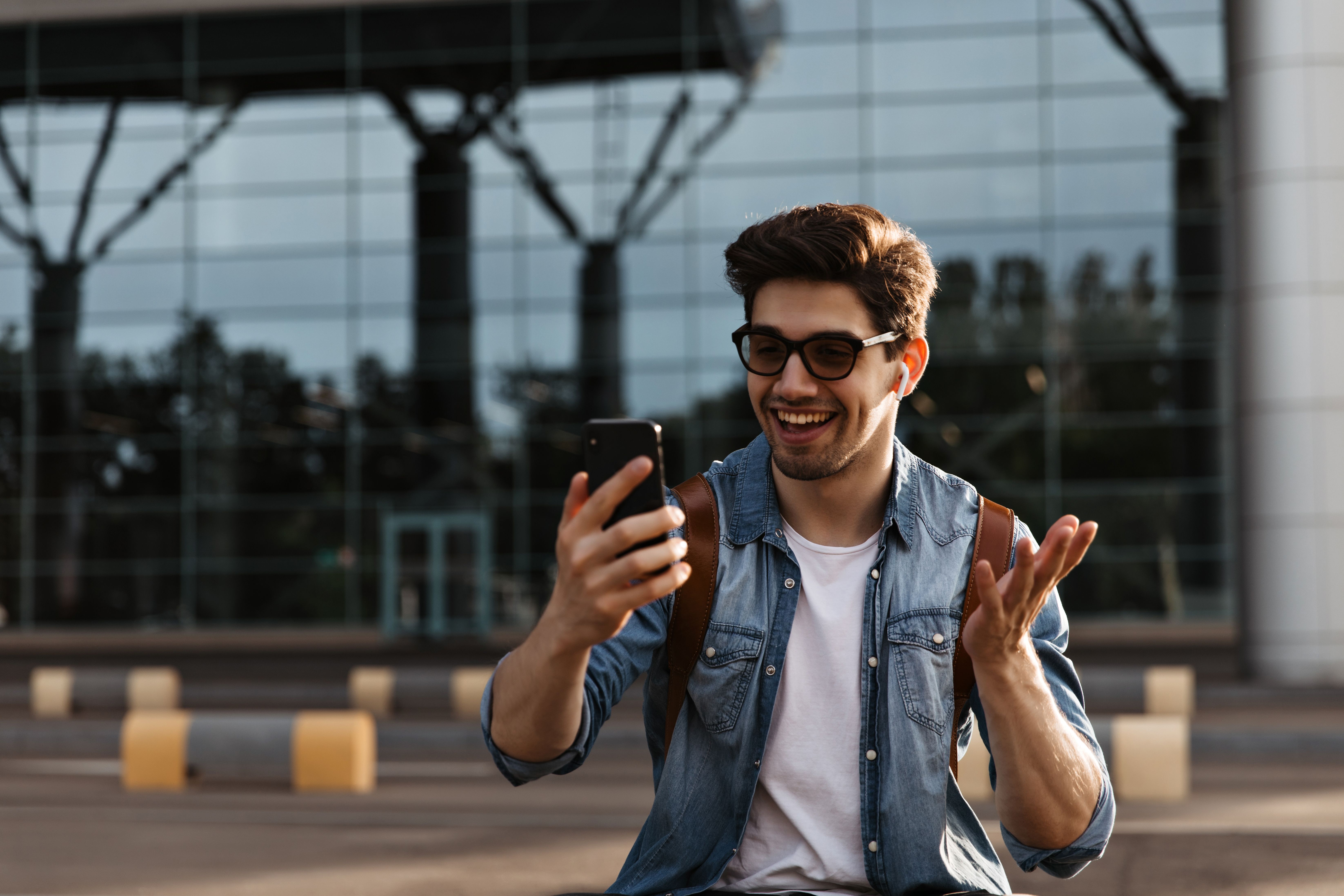 happy-brunette-man-sunglasses-denim-jacket-smiles-holds-phone-handsome-guy-takes-selfie-outside.jpg