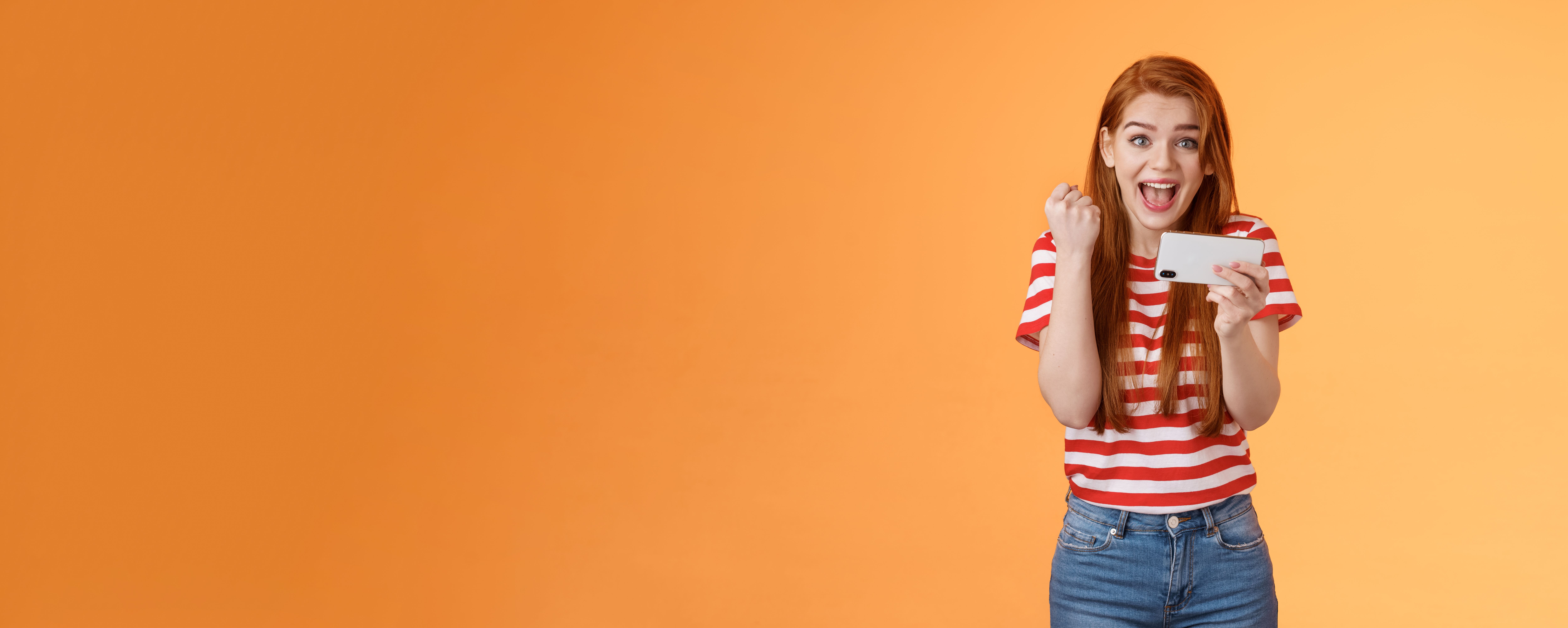 happy-excited-redhead-female-pass-level-like-awesome-game-score-goal-hold-smartphone-horizontally-fi.jpg