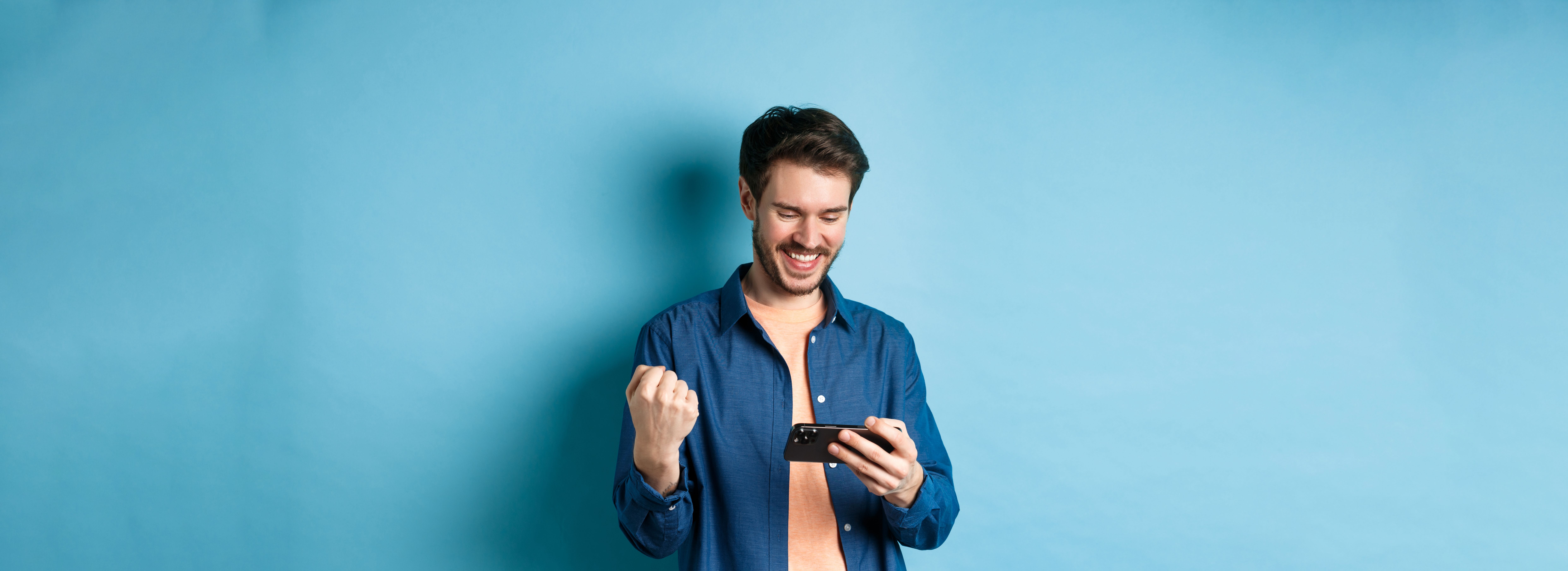 happy-young-man-winning-video-game-mobile-phone-looking-satisfied-smartphone-screen-say.jpg
