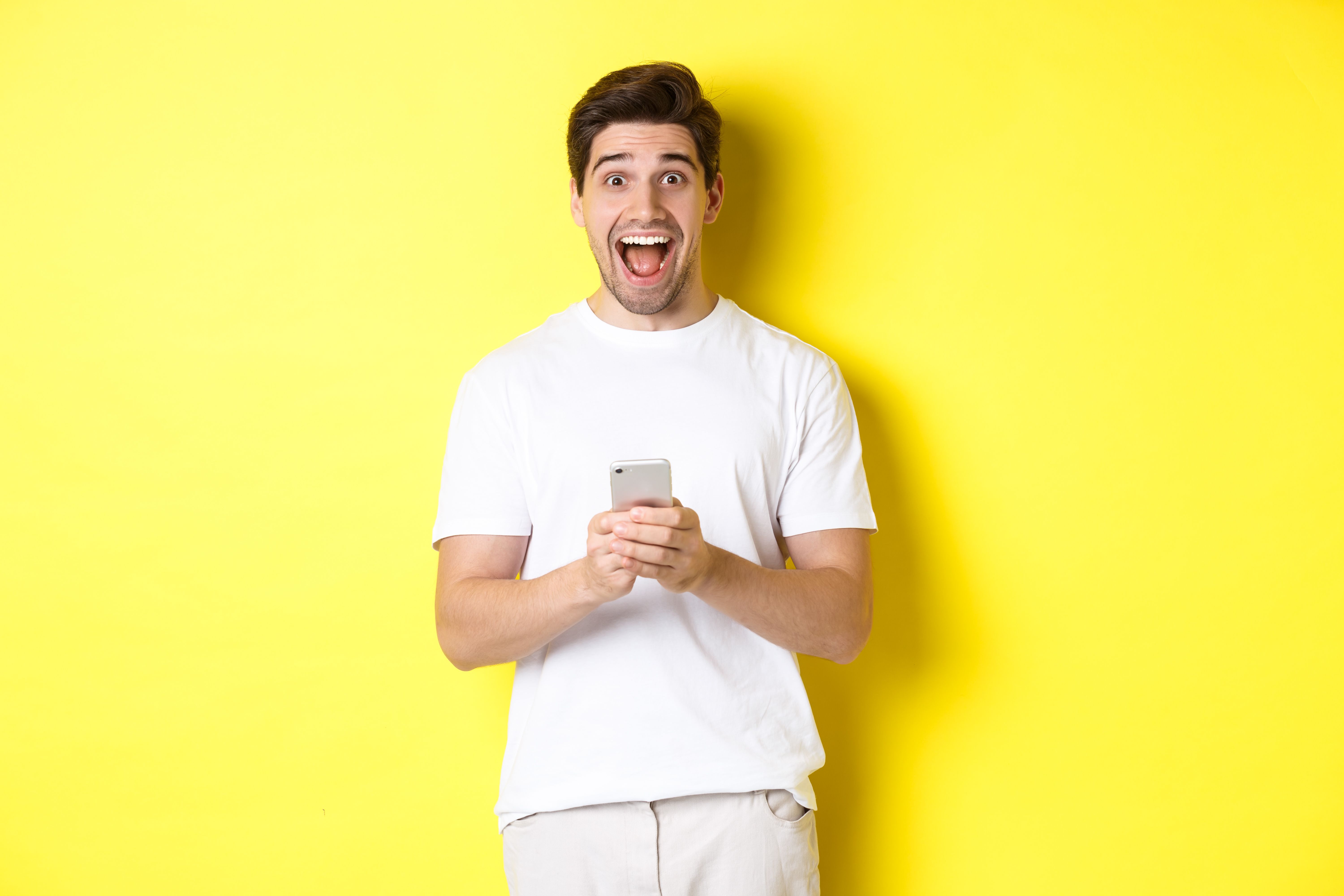 man-looking-amazed-happy-after-reading-something-mobile-phone-standing-yellow.jpg