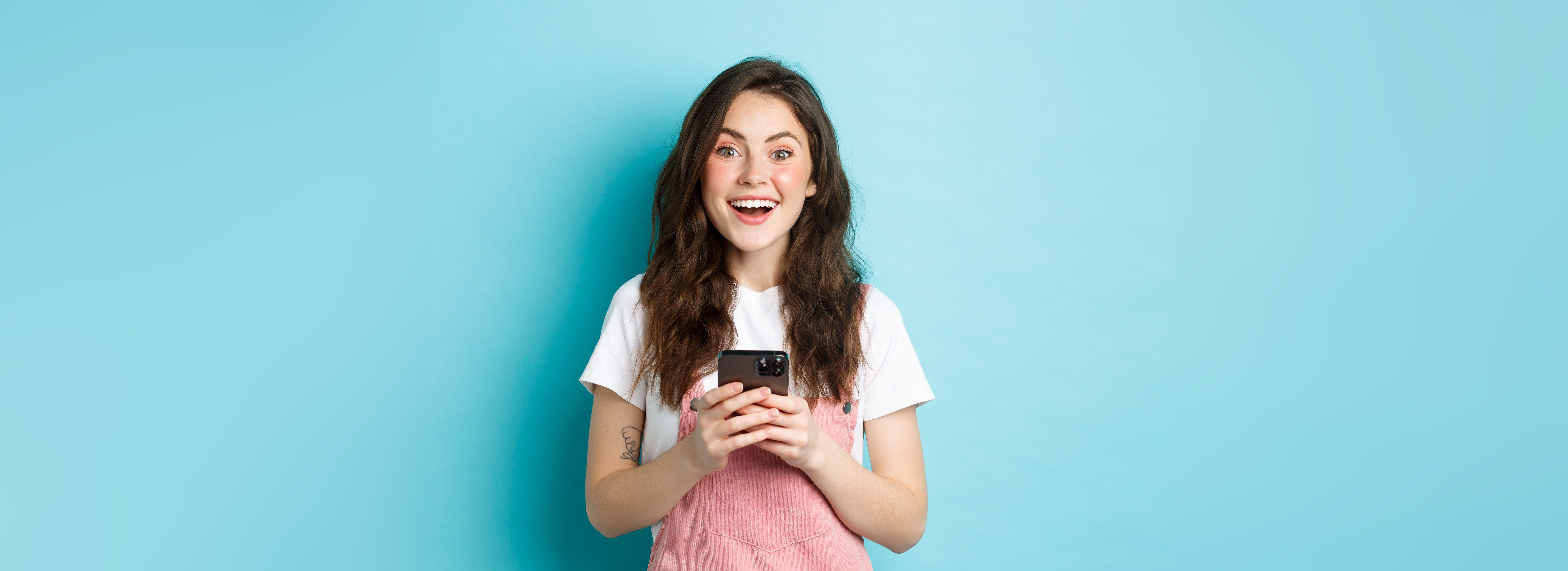 portrait-excited-brunette-girl-looking-amazed-camera-while-using-smartphone-holding-mobile-pho.jpg