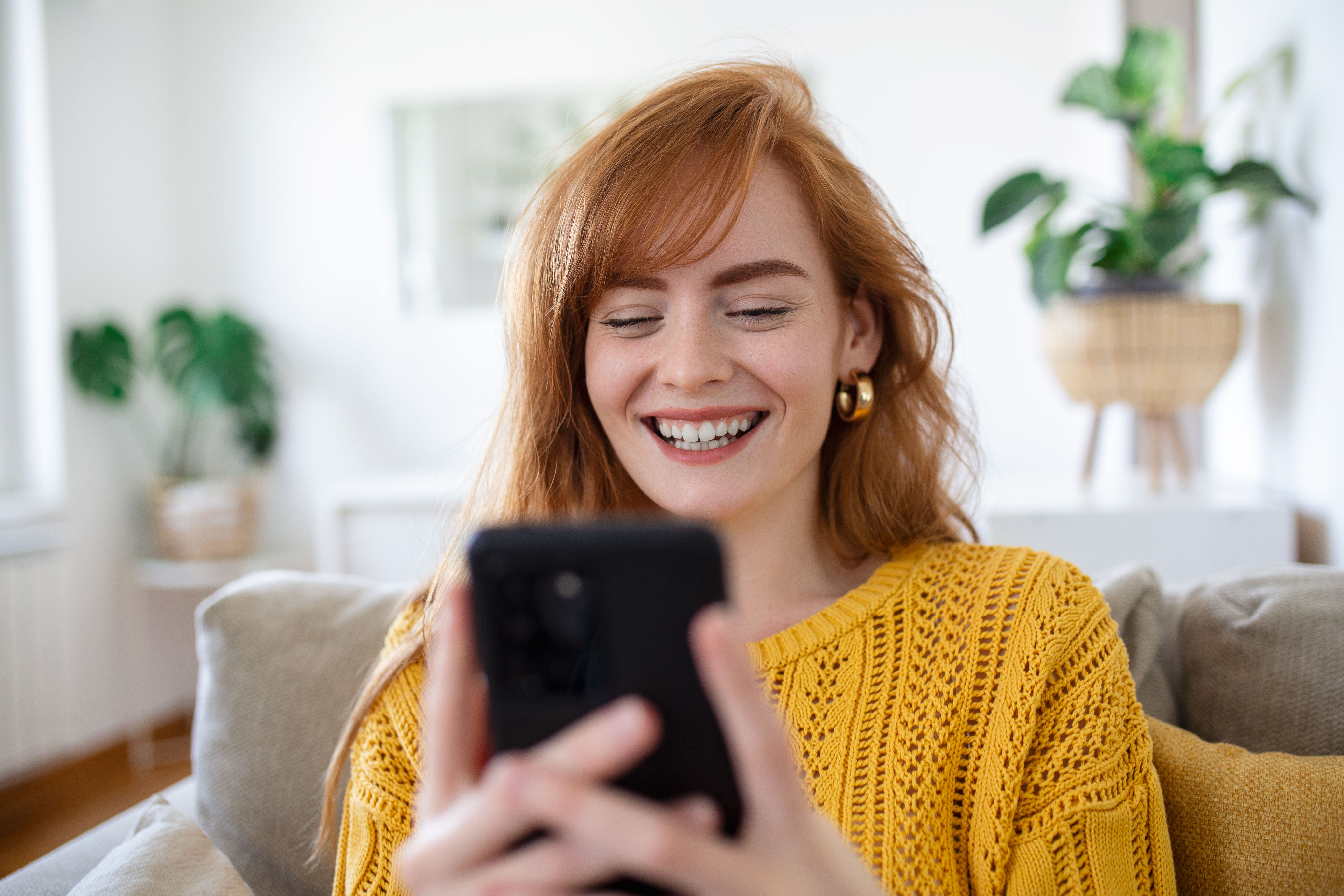smiling-pretty-young-woman-relaxes-sofa-her-living-room-while-using-her-mobile-smart-phone-social-media-surfing-internet.jpg