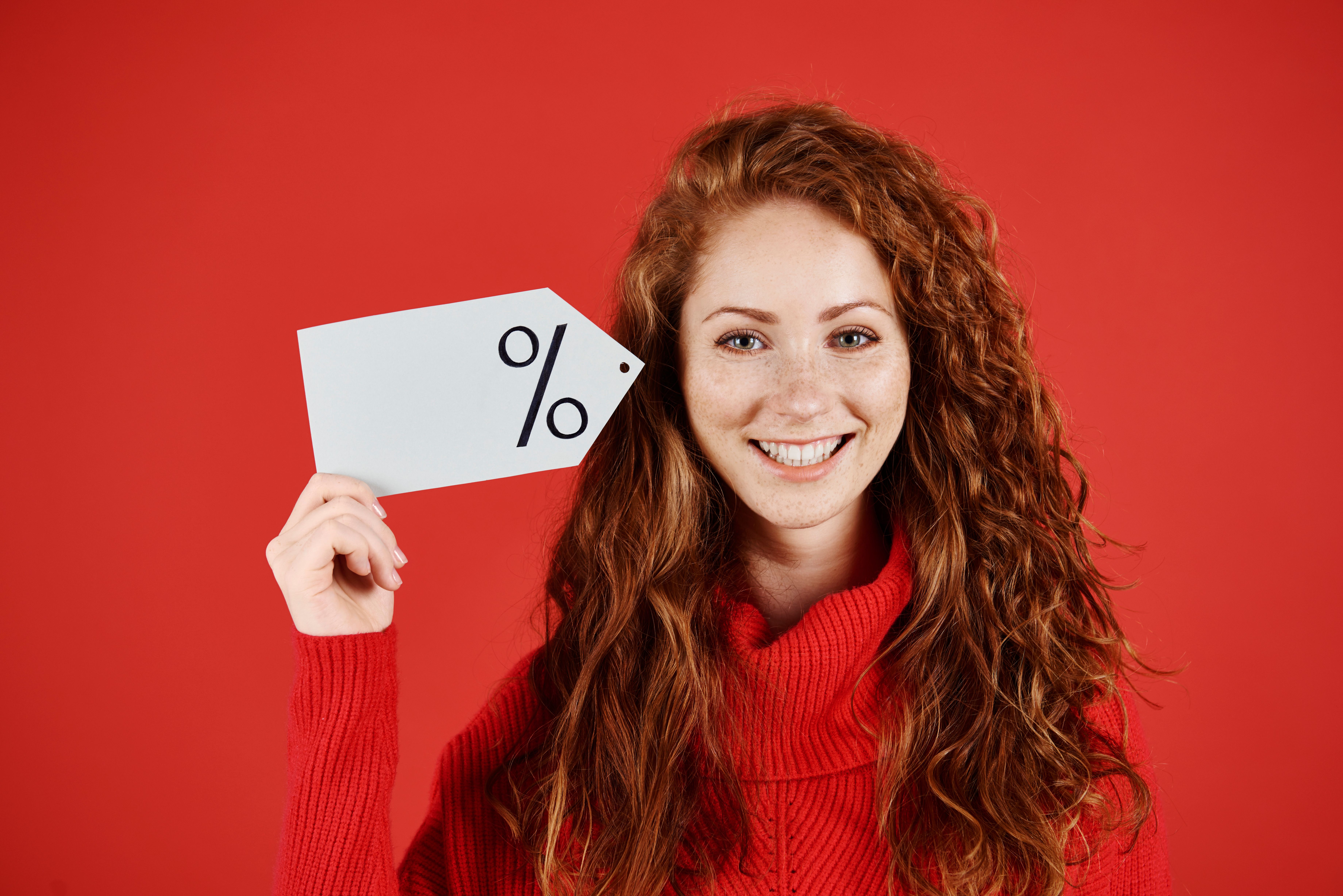 smiling-woman-holding-blank-price-tag.jpg